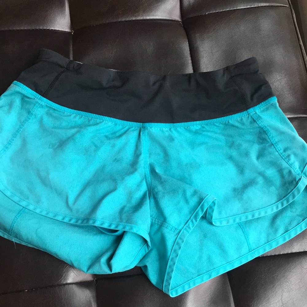 Turquoise lululemon shorts with a blotchy design.